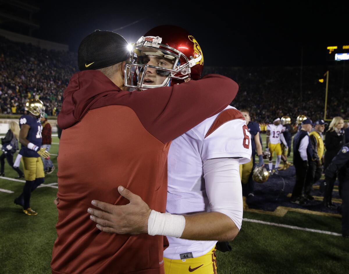 USC quarterback Cody Kessler is hugged by then-interim Coach Clay Helton following a 41-31 loss to Notre Dame in South Bend, Ind., on Oct. 17.