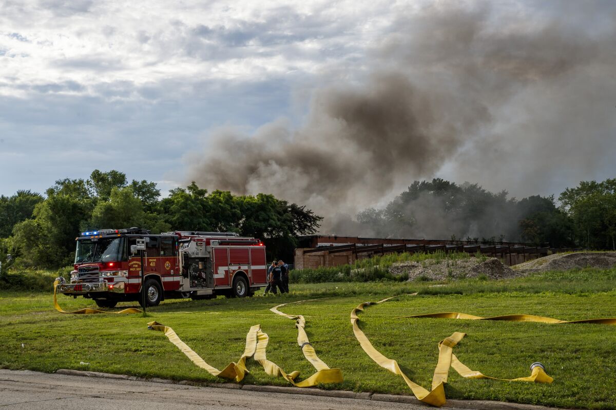 Firefighters work the scene of an industrial fire Tuesday, June 29, 2021, in Morris, Ill. Lithium batteries have been noisily exploding inside a burning abandoned paper mill in northern Illinois and firefighters are letting the blaze burn out because they fear trying to extinguish it could trigger more explosions, officials said Wednesday. (Armando L. Sanchez/Chicago Tribune via AP)