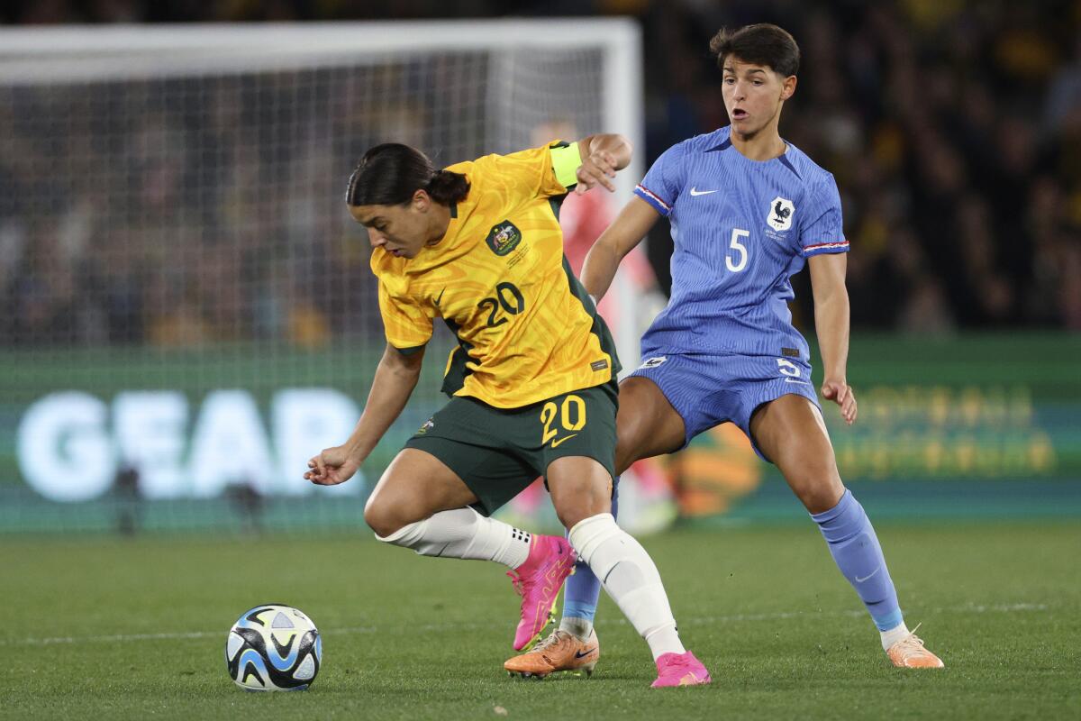 Australia's Sam Kerr tries to hold back France's Elisa De Almeida while fighting for the ball on the pitch in front of Kerr