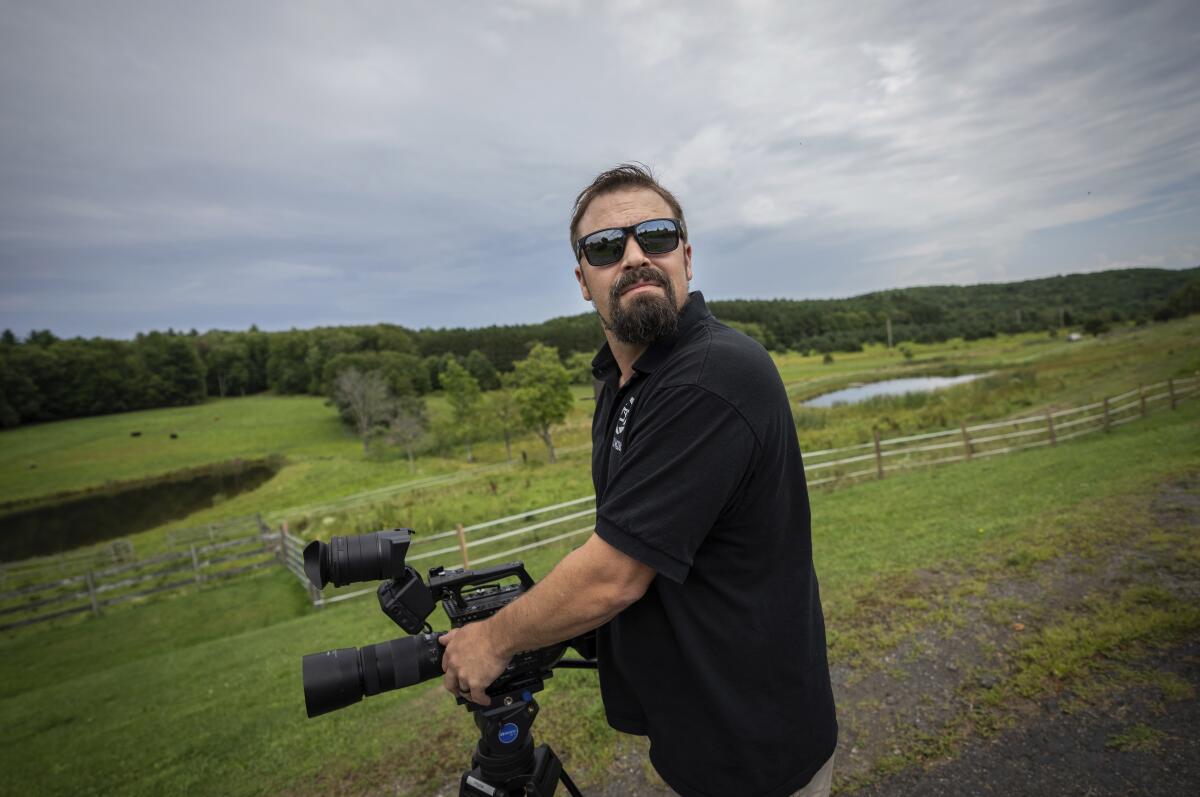 Korey Rowe carga una cámara de video cerca de su casa en Oneonta, Nueva York.