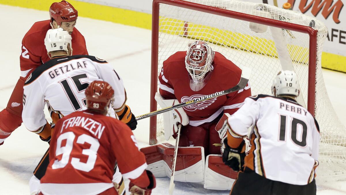 Ducks captain Ryan Getzlaf, second left, scores the winning goal past Detroit Red Wings goalie Jimmy Howard during the closing seconds of a 3-2 win Saturday.