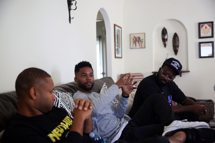 LOS ANGELES, CA-JULY 13, 2019: Rahshiene Taha, R.J. Harris, and Rashad Drakeford, left to right, converse during a book club gathering for black men on July 13, 2019, in Los Angeles, California. The group comes together every month to get a deeper understanding of rapper and activist Nipsey Hussle by reading and discussing the books that he read. This week, they discussed The Spook Who Sat By The Door. (Photo By Dania Maxwell / Los Angeles Times)