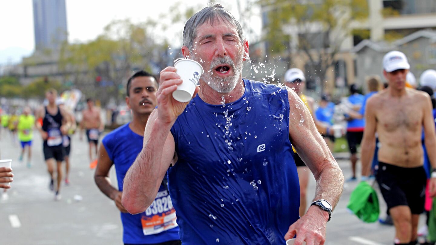 A runner hydrates on Santa Monica Blvd. during the 30th Los Angeles Marathon.