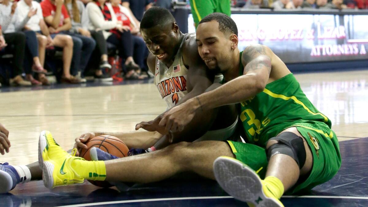 Arizona guard Rawle Alkins and Oregon forward Paul White battle for a loose ball in the first half.