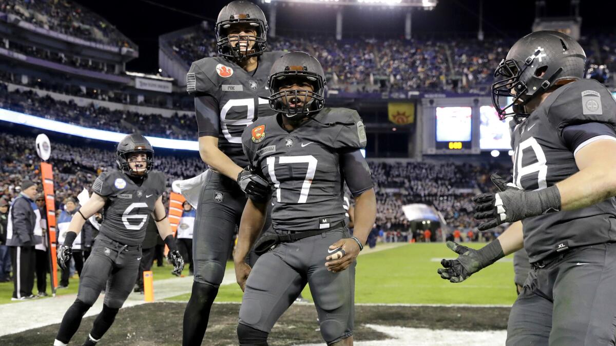 Army quarterback Ahmad Bradshaw (17) celebrates what proved to be the game-winning touchdown against Navy with teammates late in the fourth quarter Saturday.