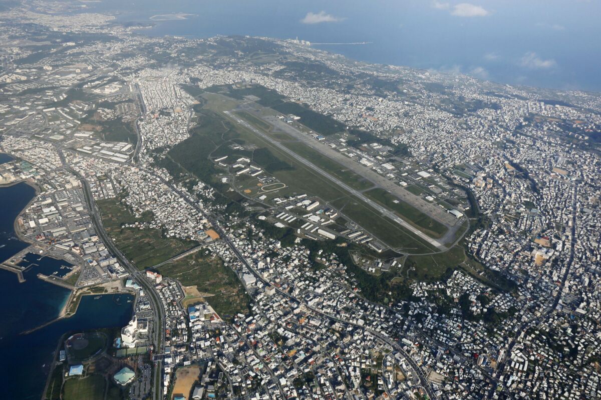 FILE - This October 2015, aerial file photo shows U.S. Marine Corps Air Station Futenma in Ginowan, Okinawa, southern Japan. Japanese defense minister said on Tuesday, July 14, 2010 that officials have discovered "a number of problems” with the U.S. military's coronavirus measures for its service members stationed in Japan after about 100 Marines have tested positive for the virus in a massive outbreak at multiple bases in Okinawa. Most of cases are at the air station. (Kazuhiko Yamashita/Kyodo News via AP, File)