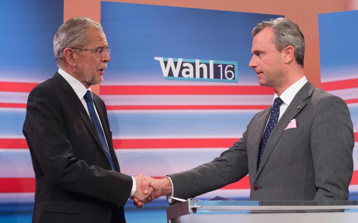 Austrian presidential candidates Alexander Van der Bellen, left, and Norbert Hofer shake hands before a TV discussion after the country's second round of voting, on May 22, 2016, at the Hofburg in Vienna.