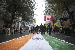An Indian flag is laid on the street as protesters wave a Canadian and Khalistan flags during a protest outside the Indian Consulate in Vancouver, British Columbia, on Monday, Sept. 25, 2023. (Darryl Dyck/The Canadian Press via AP)