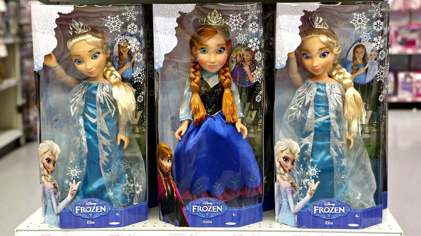 Dolls portraying sisters Elsa, left and right, and Anna from the hit 2013 movie "Frozen" are for sale at a Toys R Us in Los Angeles.