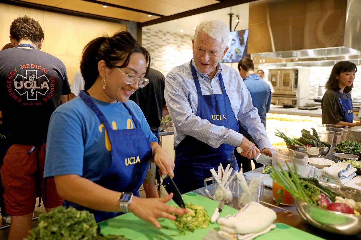 UCLA Chancellor Gene Block chops vegetables with students.