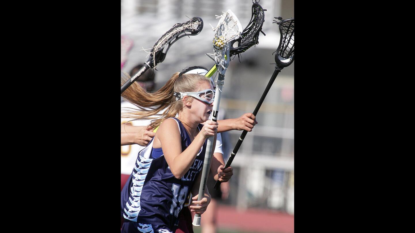 Crescenta Valley's Alexis Ballard drives between the La Cañada defense looking to shoot in a girls' lacrosse match at La Cañada High School on Tuesday, April 12, 2016. Crescenta Valley won the match 10-3.