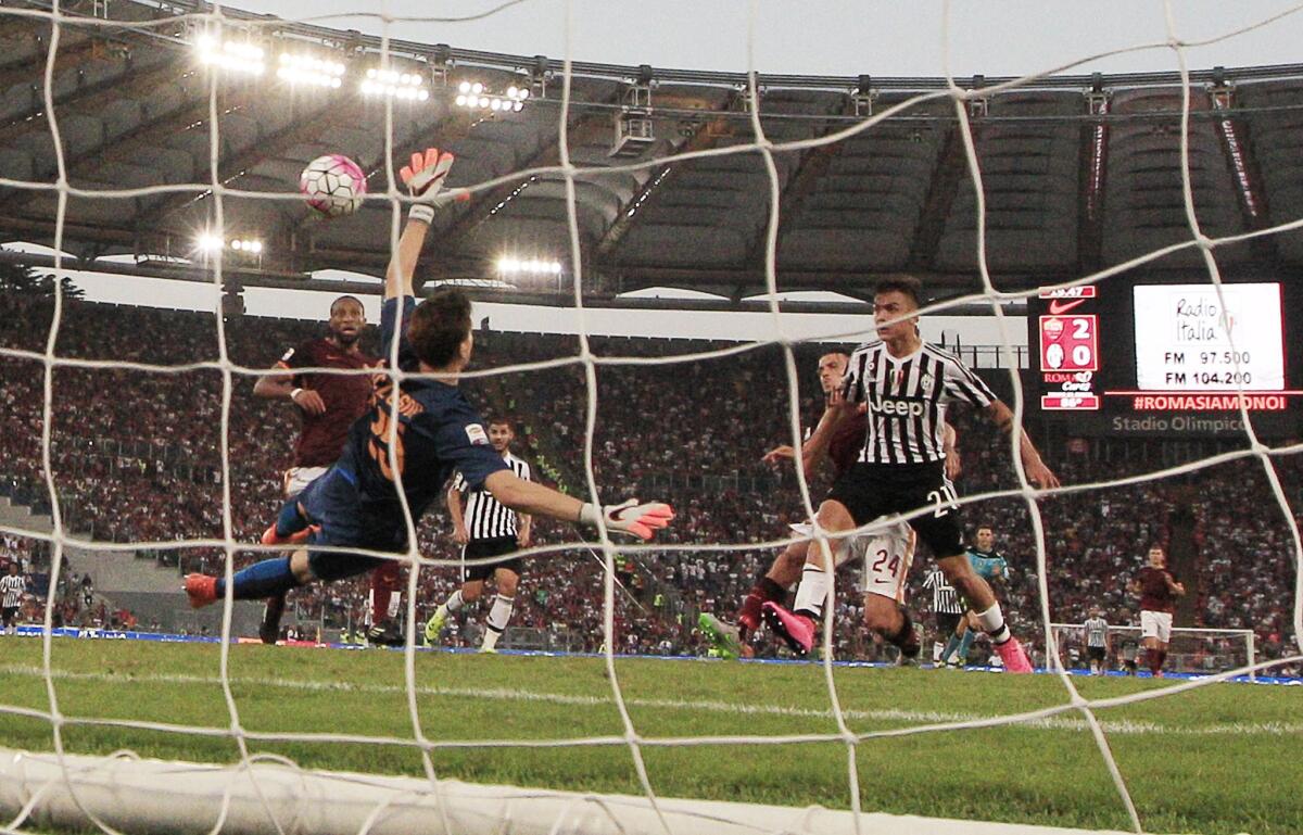 Juventus' Paulo Dybala, right, scores past Roma's goalkeeper Wojciech Szczesny during a Serie A soccer match between Roma and Juventus, at Rome's Olympic Stadium, Sunday, Aug. 30, 2015. (AP Photo/Andrew Medichini)