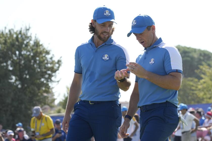 Europe's Rory Mcilroy, right with playing partner Europe's Tommy Fleetwood look at a golf ball as they walk off the 14th tee during their morning Foursome match at the Ryder Cup golf tournament at the Marco Simone Golf Club in Guidonia Montecelio, Italy, Friday, Sept. 29, 2023. (AP Photo/Andrew Medichini)
