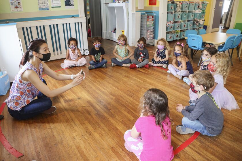 SAN DIEGO, CA - MAY 13: Teacher June Elopre (left) works with students at Le Petite Etoile 360 Preschool on Thursday, May 13, 2021 in San Diego, CA. This University Heights preschool is one of over 32,000 daycare centers listed on the site of a local tech startup called Tootris. (Eduardo Contreras / The San Diego Union-Tribune)