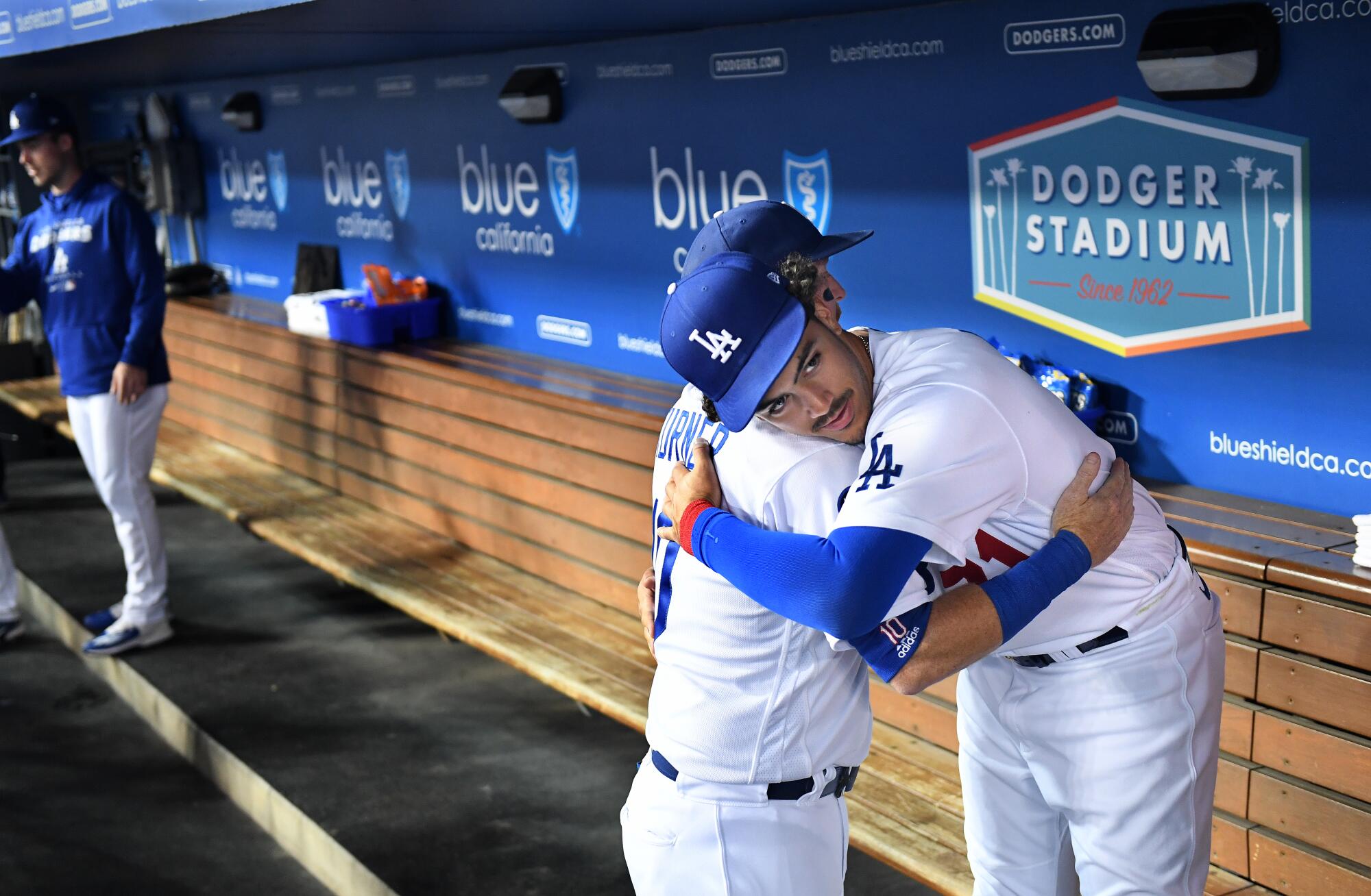 Dodgers third baseman Justin Turner, left, and Miguel Vargas embrace before a recent game.