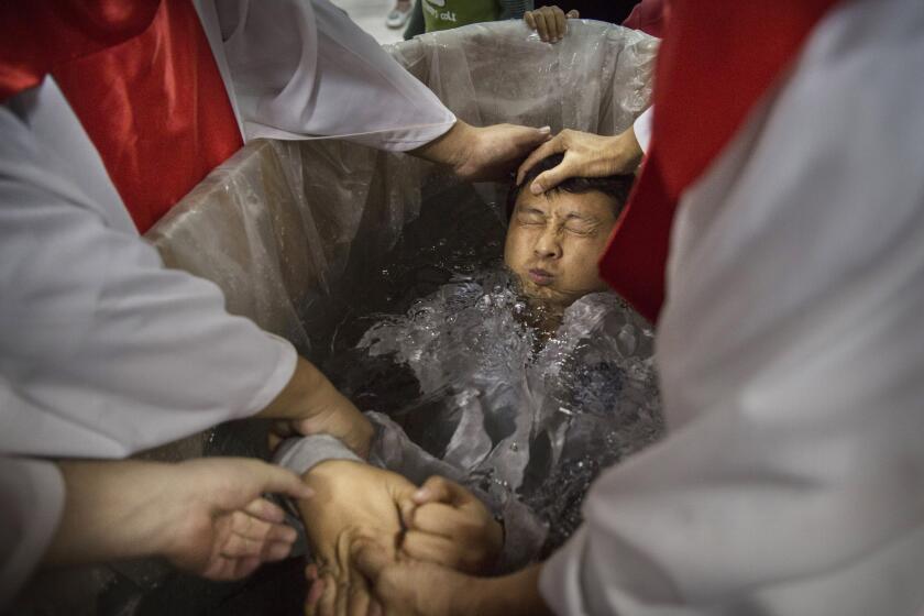 BEIJING, CHINA - OCTOBER 12:(CHINA OUT): A new Chinese Christian man is dunked in the water in a small tub as he is baptized during a ceremony at an underground independent Protestant Church on October 12, 2014 in Beijing, China. China, an officially atheist country, places a number of restrictions on Christians and allows legal practice of the faith only at state-approved churches. The policy has driven an increasing number of Christians and Christian converts 'underground' to secret congregations in private homes and other venues. While the size of the religious community is difficult to measure, studies estimate there more than 65 million Christians inside China with studies supporting the possibility it could become the most Christian nation in the world within a decade. (Photo by Kevin Frayer/Getty Images)