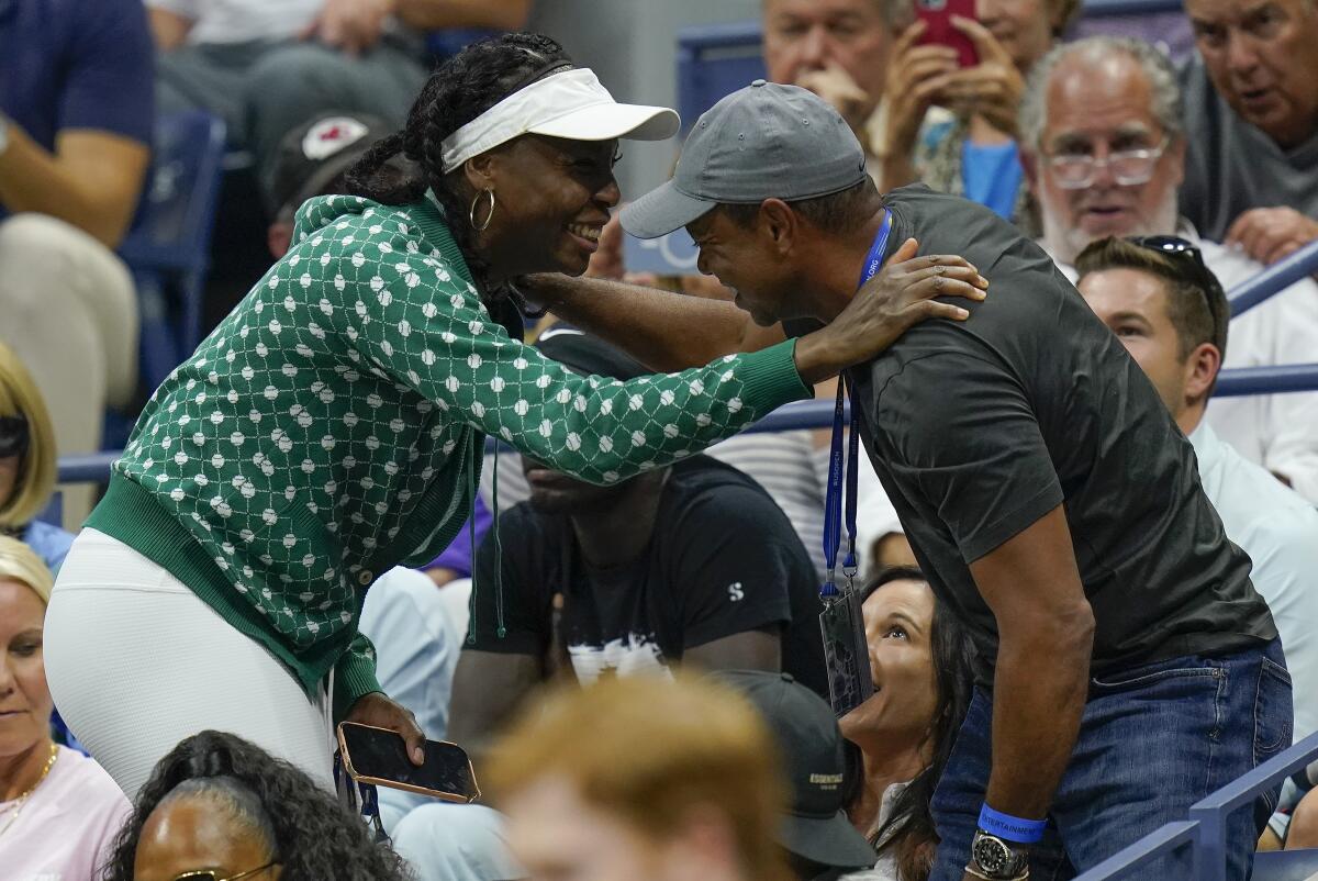 Tiger Woods, right, greets Venus Williams while watching play between Serena Williams, of the United States, and Anett Kontaveit, of Estonia, during the second round of the U.S. Open tennis championships, Wednesday, Aug. 31, 2022, in New York. (AP Photo/Seth Wenig)