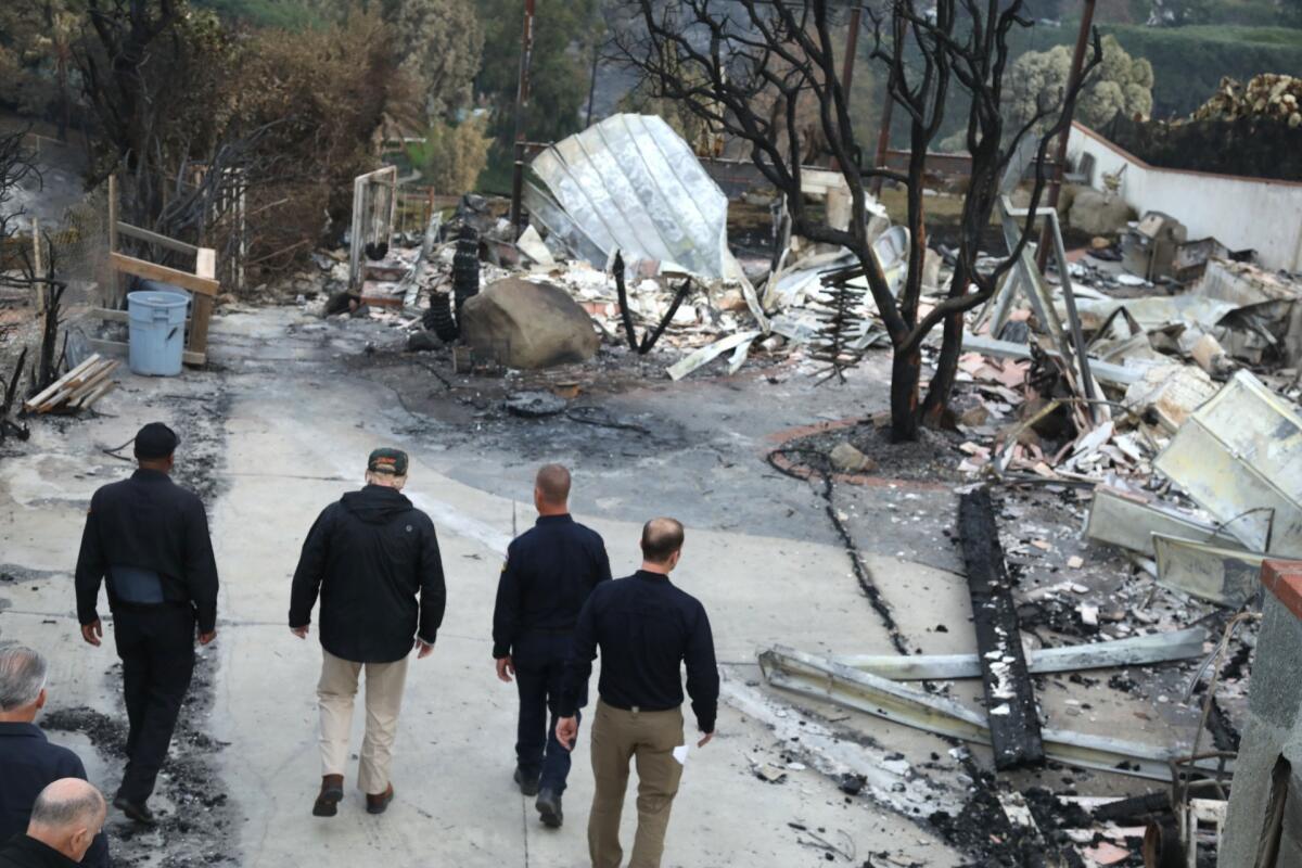 President Trump, second from left, tours a fire-ravaged neighborhood on Dume Drive in Malibu on Nov. 17.