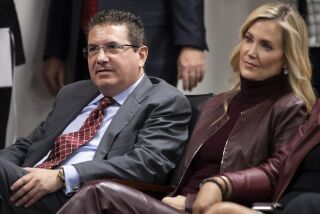 Washington Commanders owner Dan Snyder and his wife Tanya Snyder, listen to head coach Ron Rivera during a news conference