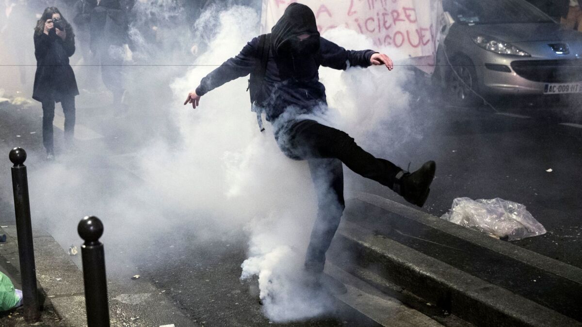 A protester in Paris kicks back a gas canister during a demonstration against police violence Feb. 15.