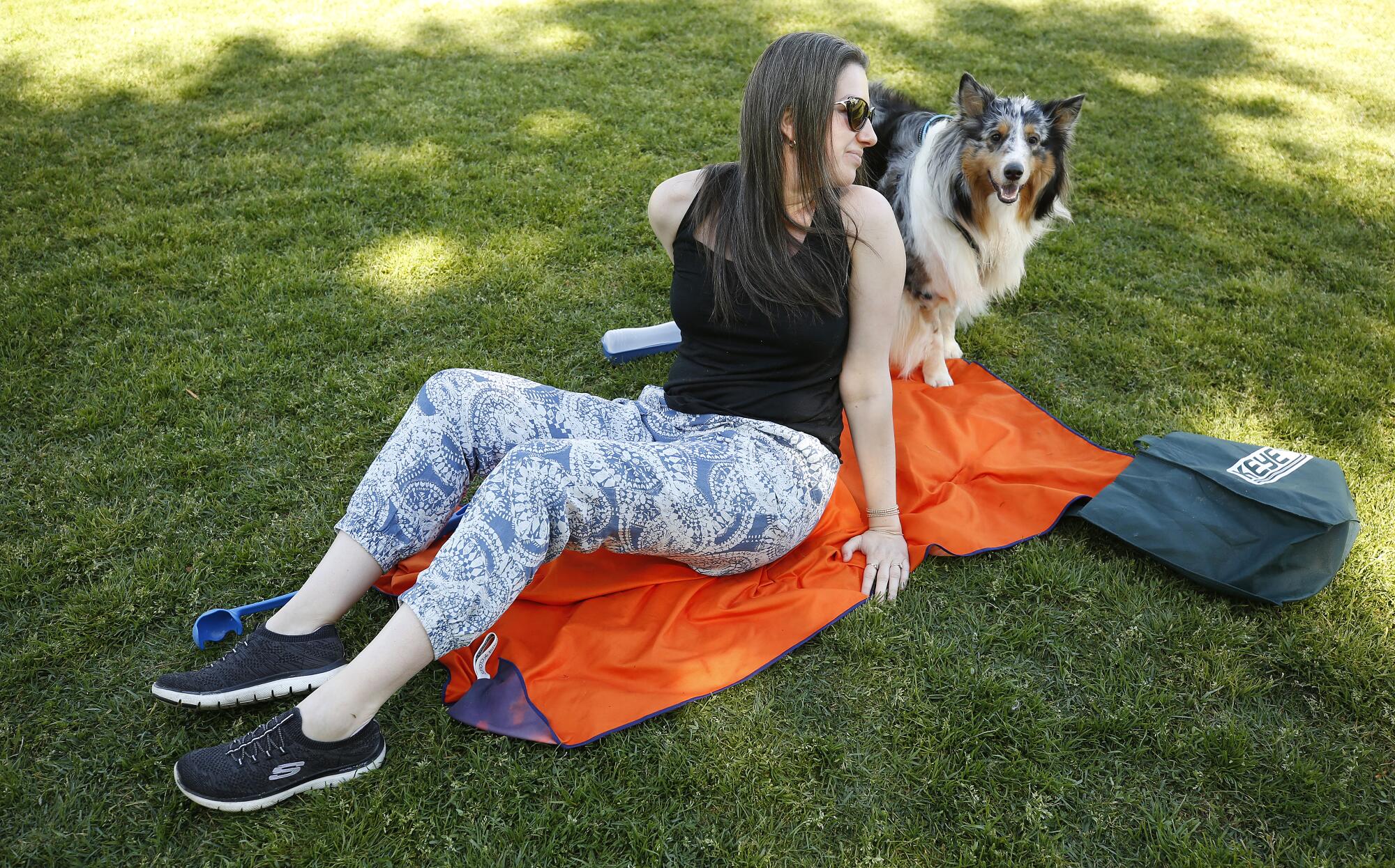 Ellie Lambert, 30, finds the shade with the family dog Charlie at Juan Bautista de Anza Park in Calabasas.