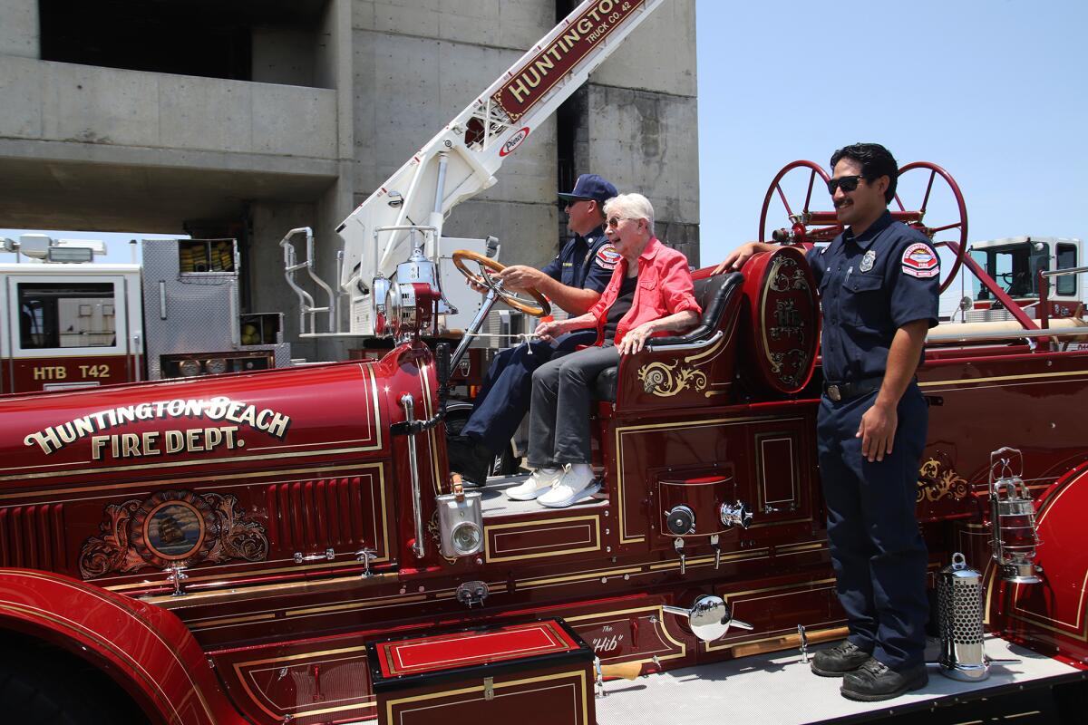 Woman enjoys ride on restored Huntington Beach fire engine, both 102 ...