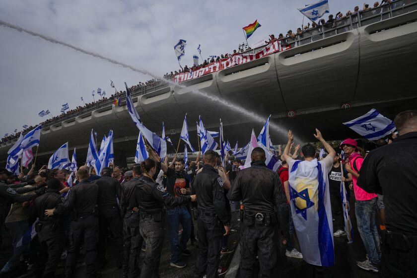 La policía israelí con cañones hidrantes dispersa una protesta contra el plan del primer ministro Benjamin Netanyahu de reformar el sistema judicial, en Tel Aviv, 23 de marzo de 2023. (AP Foto/Ohad Zwigenberg)