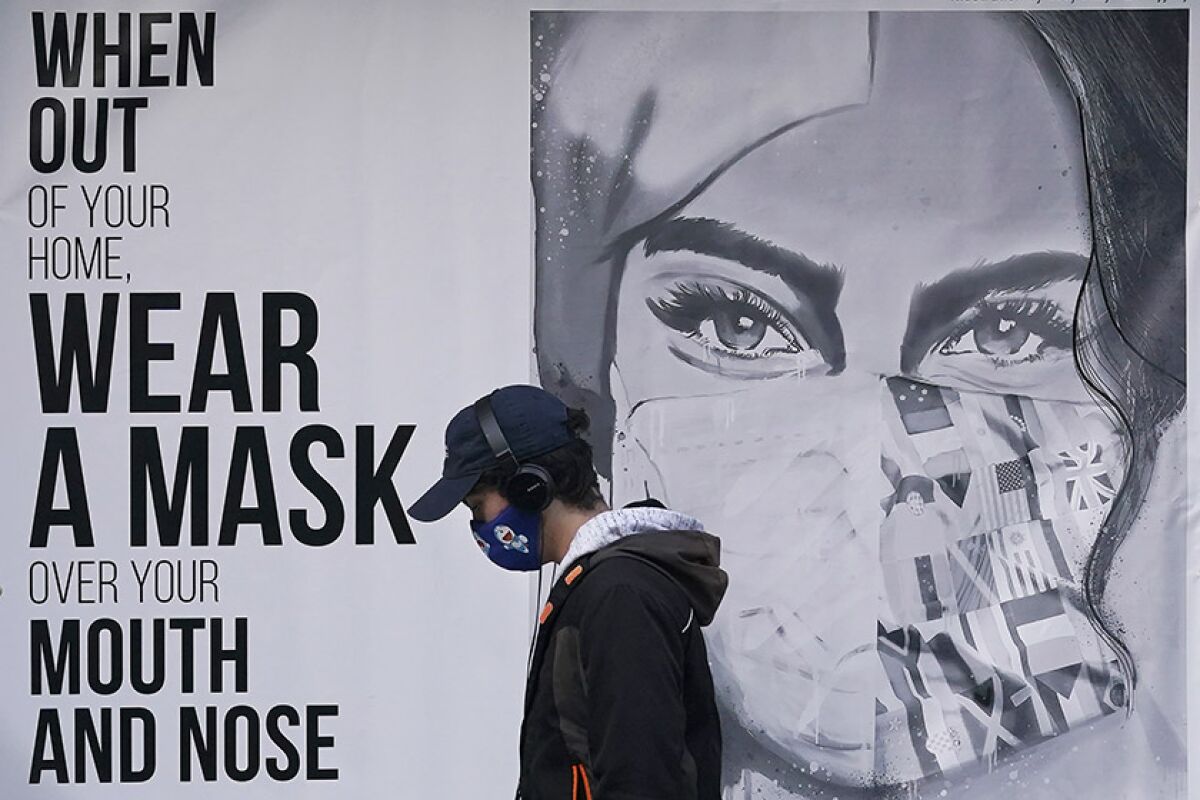 A pedestrian walks past a sign in San Francisco on Saturday.