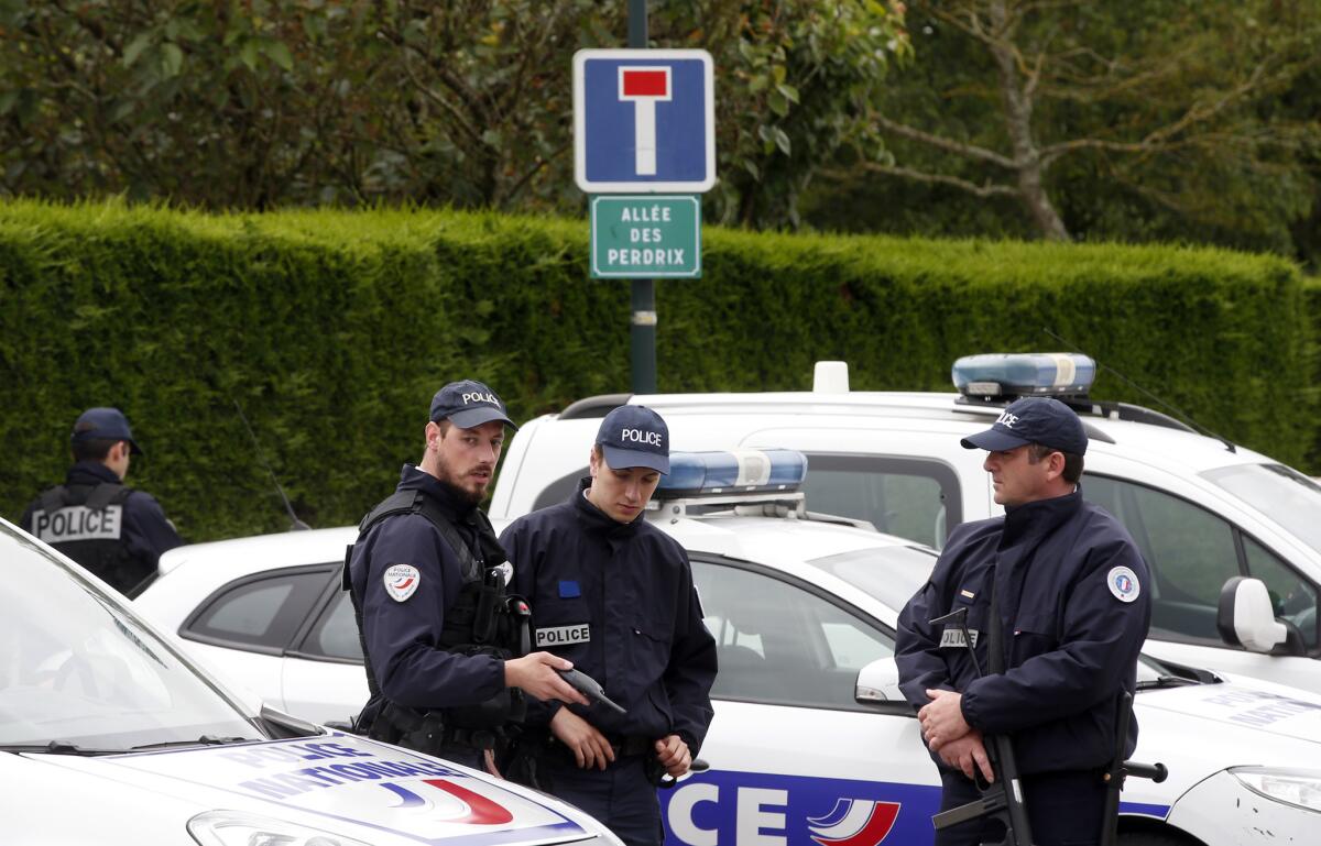 Agentes de policía bloquean el acceso a la calle que lleva al lugar donde un atacante, armado con un cuchillo, apuñaló a un comandante del cuerpo en el exterior de su casa en Magnanville, al oeste de París, el 14 de junio de 2016. (AP Foto/Thibault Camus)