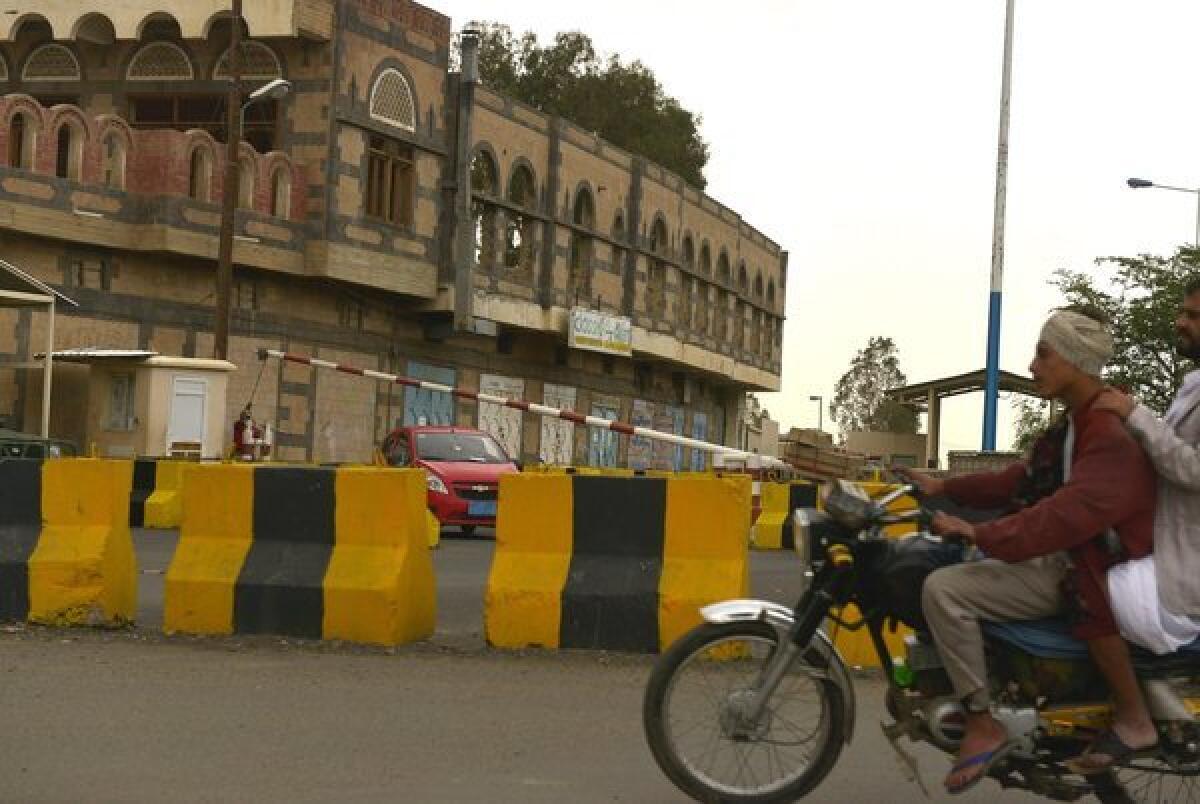 Yemenis ride a motorbike past barriers blocking the access to the U.S. Embassy in Sana, Yemen, on Saturday.