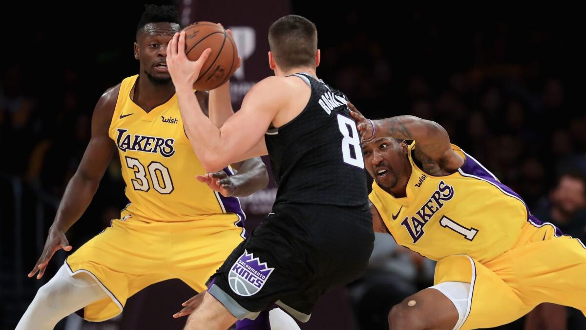 Lakers' Julius Randle (30) and Kentavious Caldwell-Pope defend against Sacramento's Bogdan Bogdanovic on Jan. 9 at Staples Center.