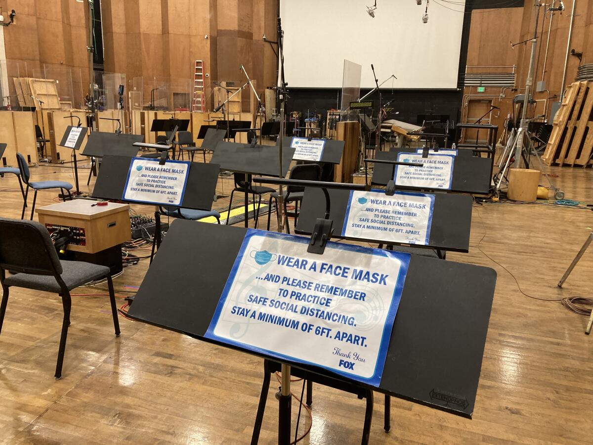 A sign on a music stand reads, in part: "Wear a face mask and please remember to practice safe social distancing."