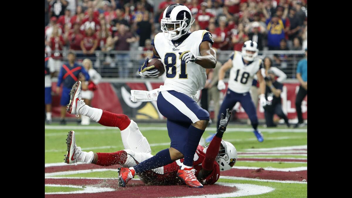Rams tight end Gerald Everett scores a touchdown as Arizona Cardinals safety Budda Baker defends during the first half.