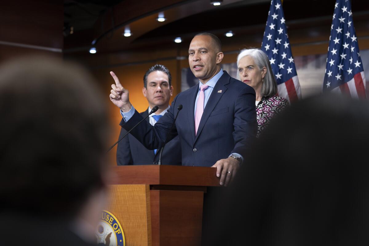 Hakeem Jeffries stands at a lectern.