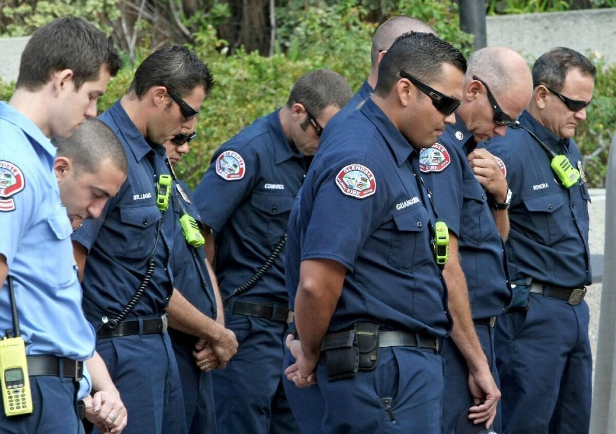 Glendale firefighters observe a moment of silence during a gathering at Perkins Plaza to honor victims on 9/11 on Wednesday, September 11, 2013.