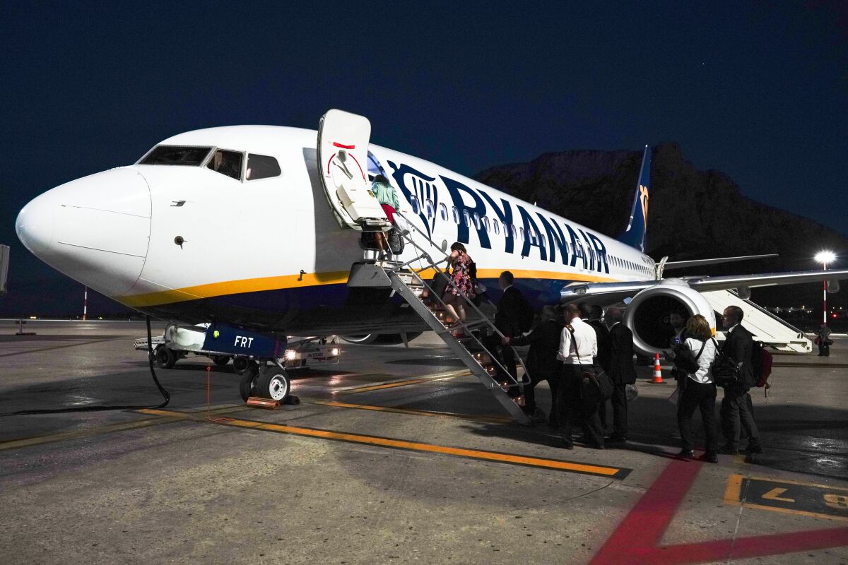 Passengers board a Ryanair airplane, in Palermo, Italy, Saturday, Sept. 15, 2018. Italy’s aviation authority, ENAC, has put RyanAir on notice that it has ‘’repeatedly violated’’ rules aimed at curbing the spread of coronavirus, warning that the budget carrier risks suspension in Italy unless it complies. ENAC said in a statement Wednesday, Aug. 5, 2020 that RyanAir had repeatedly disregarded rules, calling it ‘’behavior disrespectful of the health measures in Italy.’’ They include requiring passengers to wear masks, restricting baggage on board to small items placed in plastic bags and preventing crowding at baggage pickup. (AP Photo/Andrew Medichini)