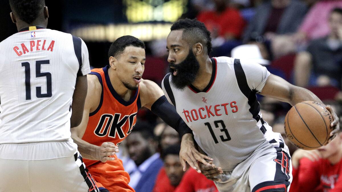 Rockets guard James Harden uses a screen from teammate Clint Capela to drive past Thunder guard Andre Roberson during the second half Sunday. (Michael Wyke / Associated Press)