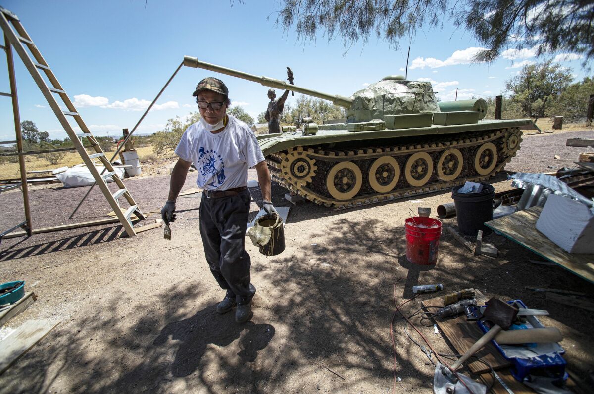 Chen Weiming takes a break from sculpting a military tank replica as part of his life-size monument called "Tank Man" in remembrance of the 30th anniversary of the Tiananmen Square massacre in Newberry Springs, Calif.