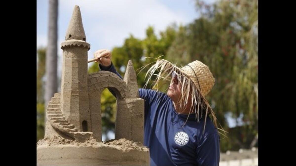 Chris Crosson carves the main tower on a sand castle for the “Sandscapes” display at Sherman Library & Gardens.