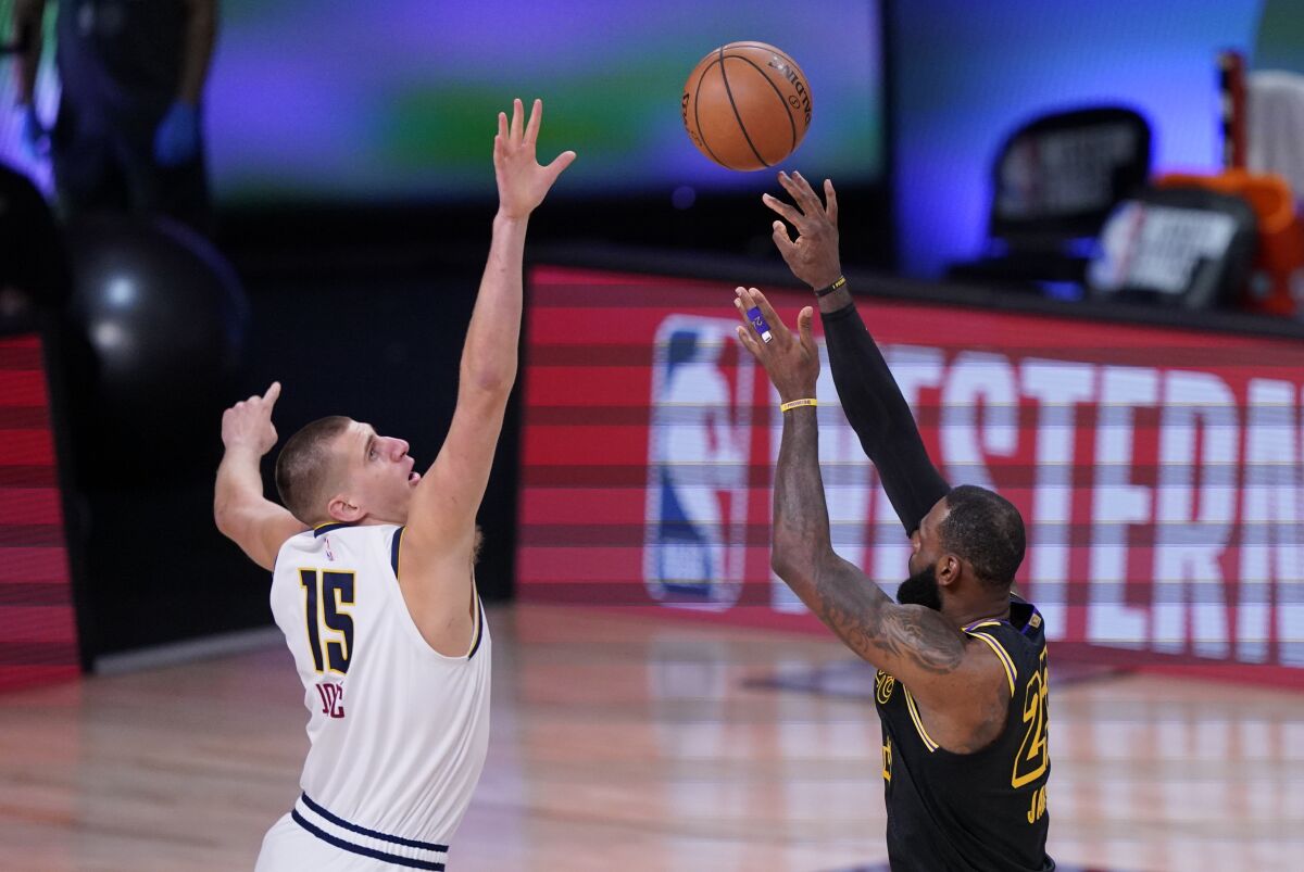 Lakers forward LeBron James lofts a shot over Nuggets center Nikola Jokic durig Game 2.