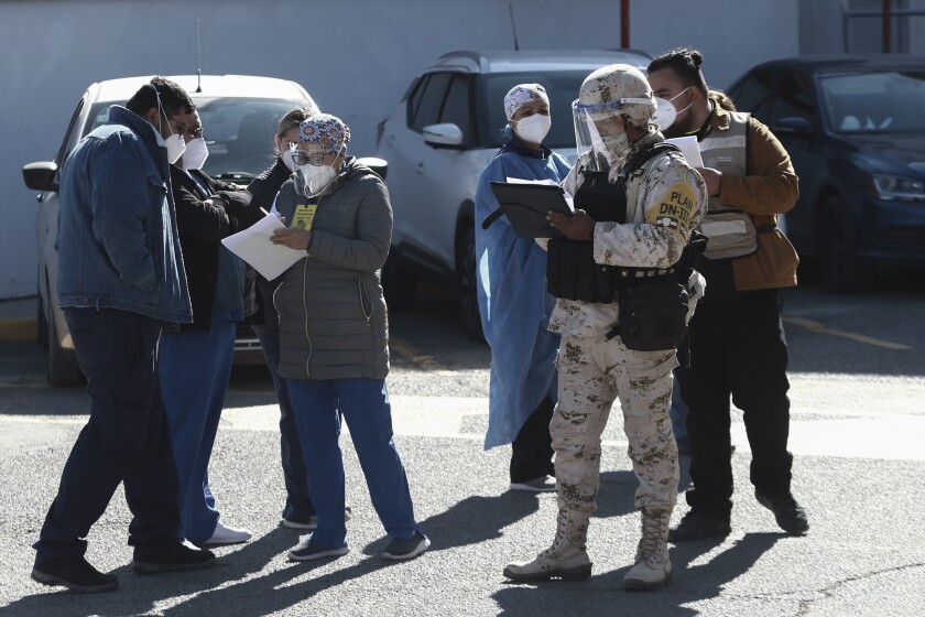 Medical workers are registered to receive the Pfizer COVID-19 vaccine, outside a vaccination center at General Hospital on the first day of coronavirus vaccinations in Ciudad Juarez, Mexico, Wednesday, Jan. 13, 2021. (AP Photo/Christian Chavez)