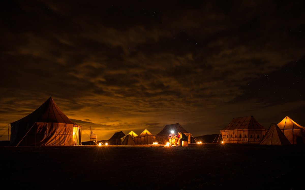 the North Africa sky sprawls above an Agafay Desert campsite in Morocco.