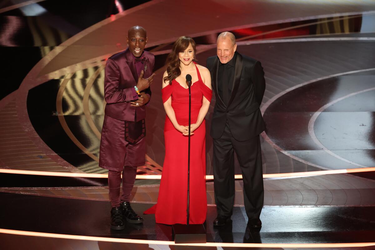 Three people on stage in front of  a mic