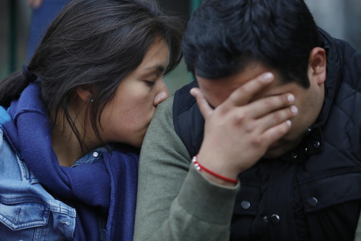 Alejandra Reynoso, left, and boyfriend Alejandro Gamez wait for news on Gamez's sister, who was missing at a collapsed office building.