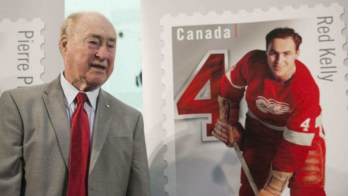 Former Detroit Red Wings player Red Kelly stands beside his Canadian stamp during the unveiling of the NHL stamp series featuring defensemen from the original six NHL teams at the Hockey Hall of Fame in Toronto on Feb. 1.