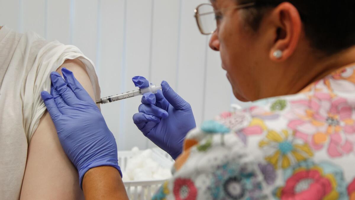 Brandon Pitogogets a flu shot from Lupita Baeza, a registered nurse at a San Diego County immunization clinic in January, 2018.