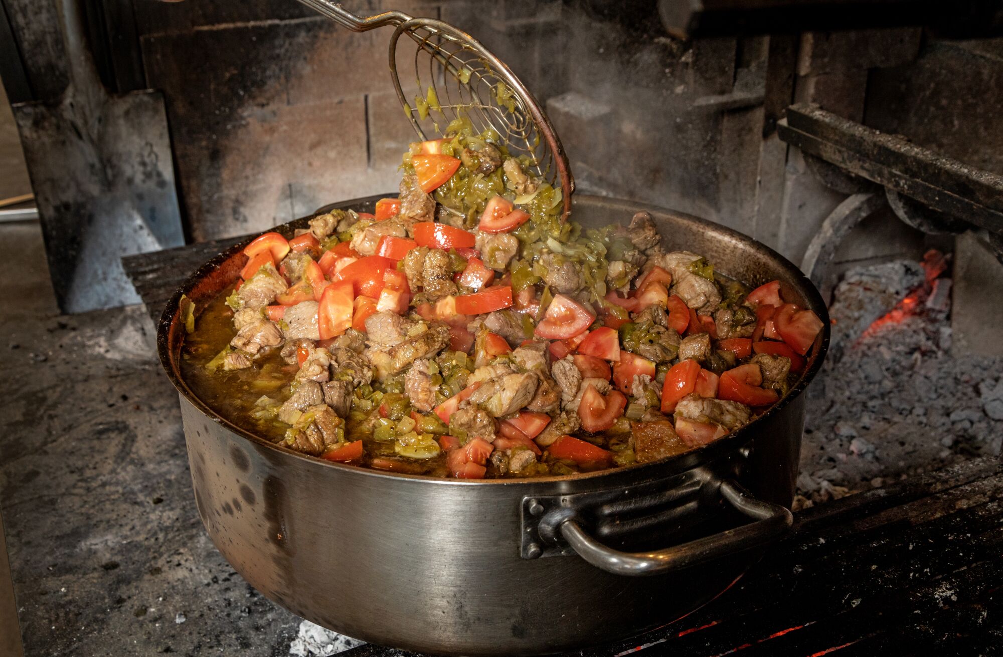 At Dunsmoor in Los Angeles, a large pot or stew filled with chunks of pork, chiles and tomatoes.