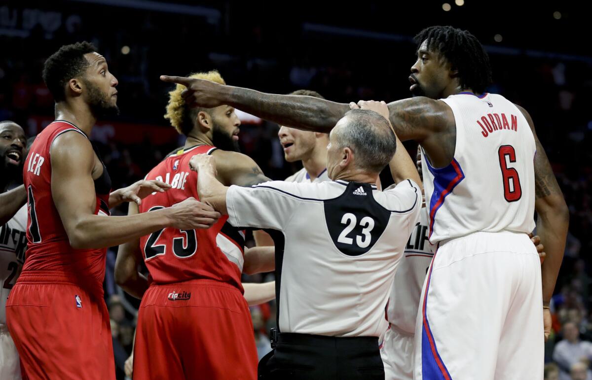 Referee Jason Phillips breaks up an altercation Dec. 12 between the Clippers' DeAndre Jordan and Portland's Evan Turner.