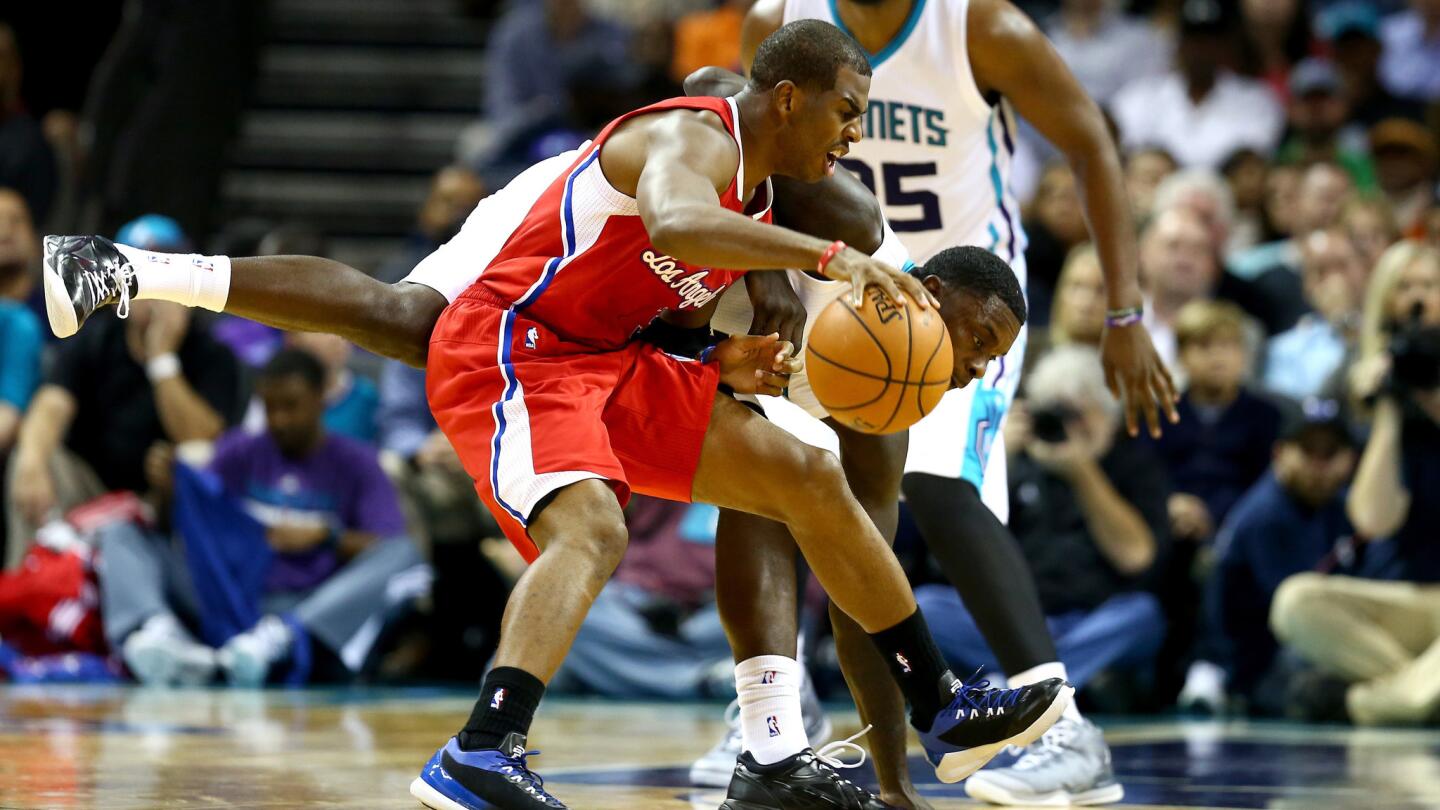 Clippers point guard Chris Paul, front, tries to avoid Charlotte Hornets guard Lance Stephenson during the first half of Monday's game.
