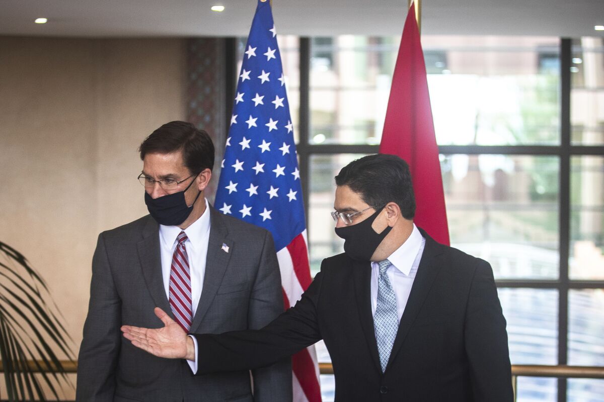 US Secretary of Defense Mark Esper, left, is received by Moroccan Foreign Minister Nasser Bourita, right, in Rabat, Morocco, Friday, Oct. 2, 2020. The visit is part of US Defense Secretary Mark Esper's North Africa tour and is his first visit to Africa as defense secretary. (AP Photo/Mosa'ab Elshamy)